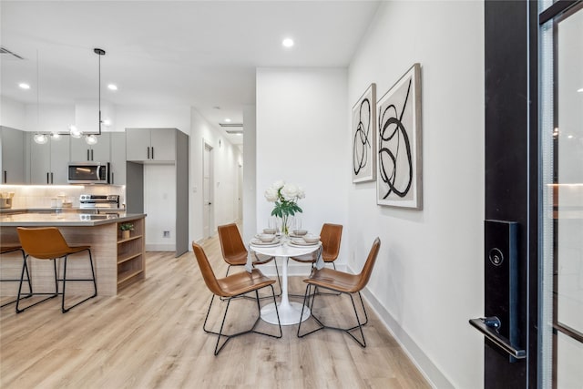 dining space with recessed lighting, visible vents, baseboards, and light wood finished floors