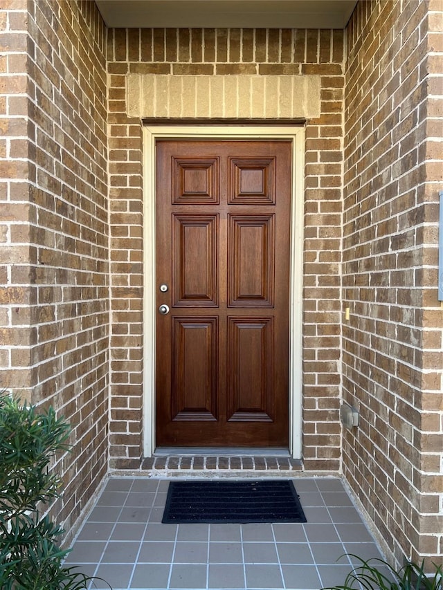 doorway to property with brick siding