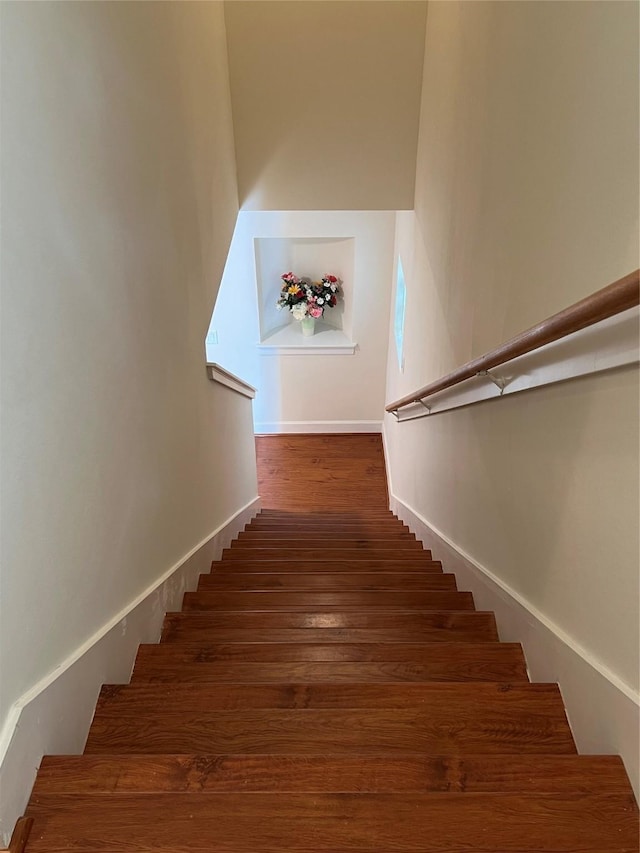 stairs featuring wood finished floors and baseboards