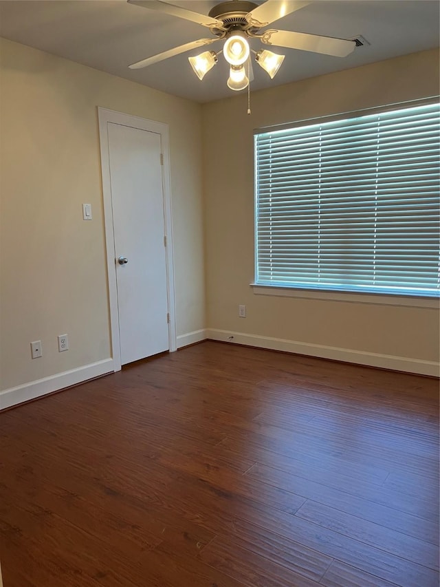 unfurnished room with dark wood-style floors, ceiling fan, and baseboards