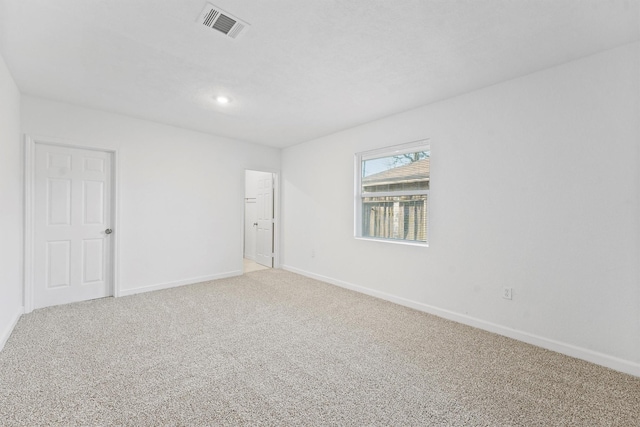 unfurnished room featuring baseboards, visible vents, and light carpet