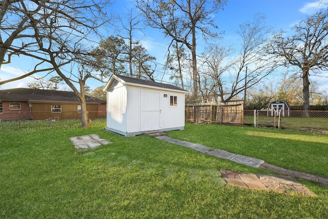 view of yard featuring an outbuilding, a fenced backyard, and a shed