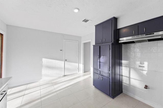 kitchen with visible vents, tasteful backsplash, a textured ceiling, light tile patterned floors, and baseboards