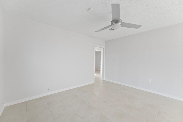 spare room with visible vents, a ceiling fan, baseboards, and a textured ceiling