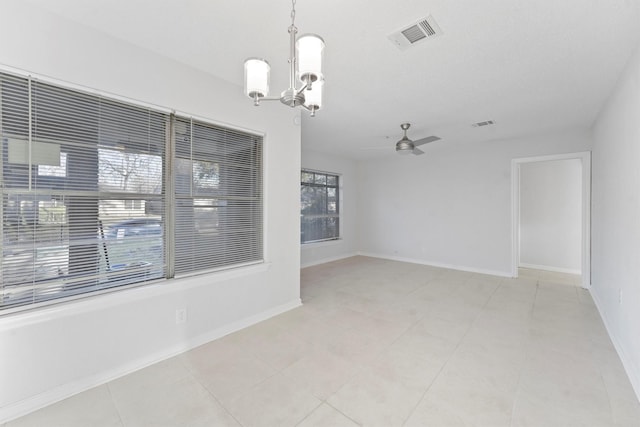 unfurnished room featuring ceiling fan with notable chandelier, light tile patterned floors, baseboards, and visible vents