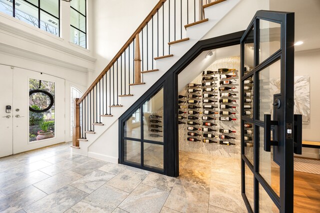 wine area featuring stone finish flooring, baseboards, and a towering ceiling
