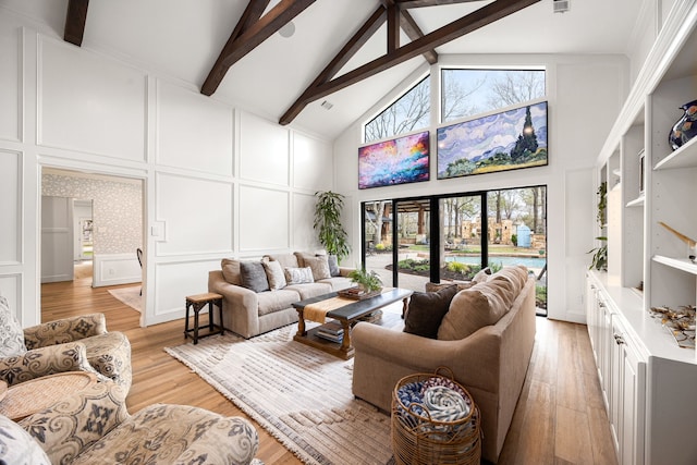 living room with high vaulted ceiling, a decorative wall, beam ceiling, and a wealth of natural light