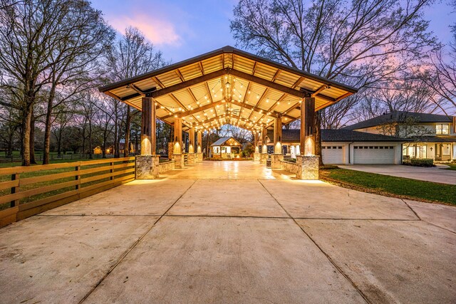 view of property's community featuring fence, driveway, a gazebo, and a garage