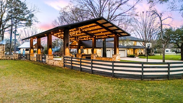 surrounding community with driveway, fence, and a yard