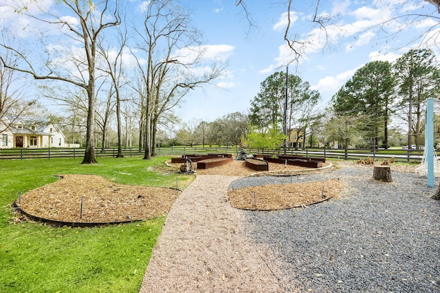 view of home's community with a lawn and fence