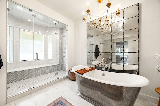 bathroom featuring a freestanding tub, marble finish floor, an inviting chandelier, a shower stall, and baseboards