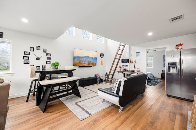 living room with recessed lighting, a healthy amount of sunlight, visible vents, and light wood-type flooring