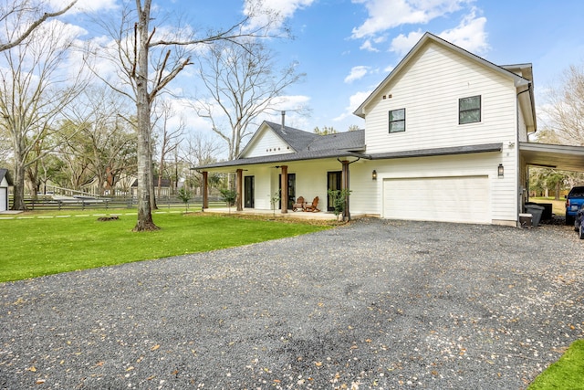 view of front of house with an attached carport, gravel driveway, fence, a porch, and a front yard