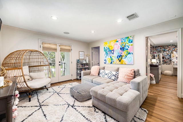 living area featuring wood finished floors, french doors, ornamental molding, visible vents, and recessed lighting