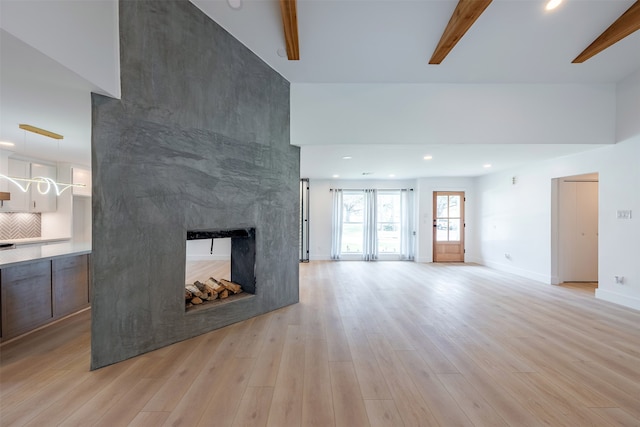 unfurnished living room with recessed lighting, baseboards, a multi sided fireplace, and light wood-style floors