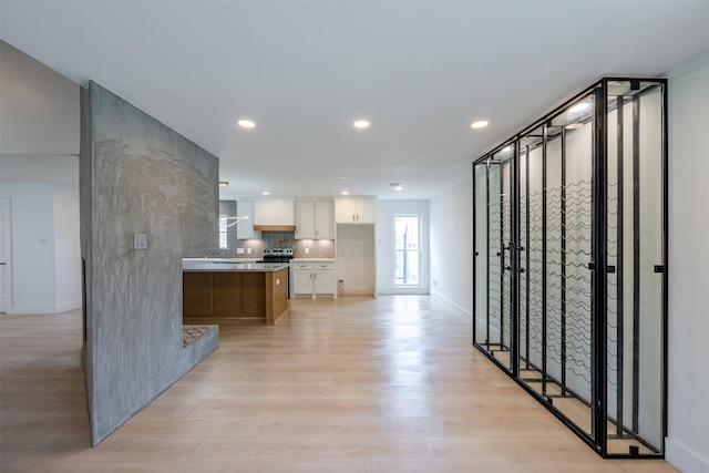 kitchen featuring tasteful backsplash, recessed lighting, light wood-style floors, white cabinets, and light countertops