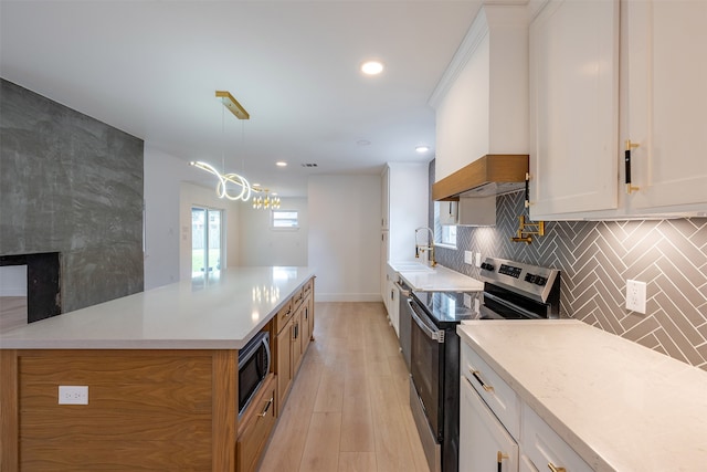 kitchen featuring backsplash, light countertops, white cabinets, stainless steel appliances, and a sink