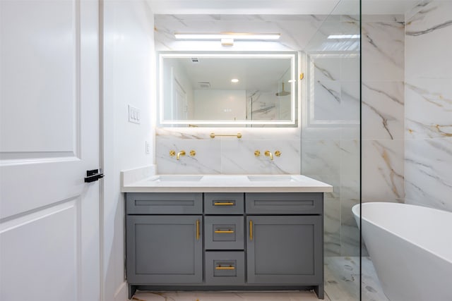 full bath with a sink, a freestanding tub, marble finish floor, and double vanity