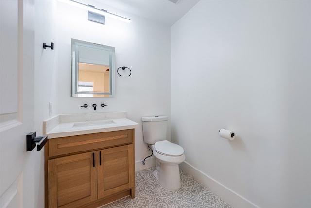 half bath featuring vanity, toilet, and baseboards