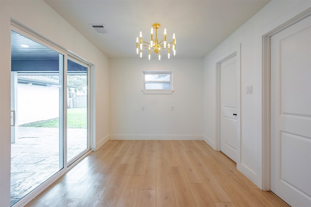 unfurnished dining area with light wood-style flooring, a notable chandelier, visible vents, and a wealth of natural light