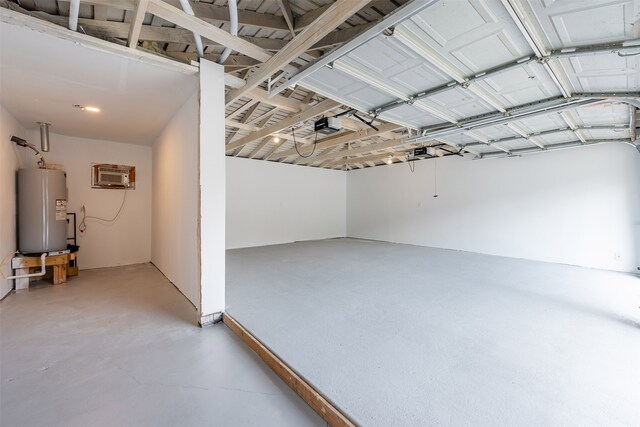 garage with a wall unit AC, a garage door opener, and water heater