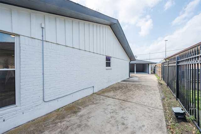 view of property exterior featuring an outbuilding, fence, and brick siding