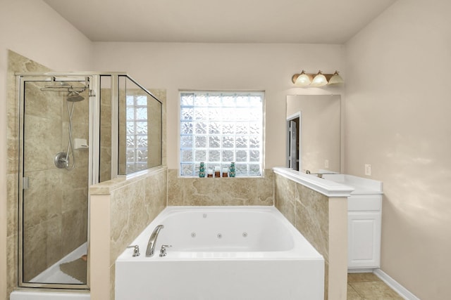 bathroom featuring tile patterned flooring, a tub with jets, a stall shower, and baseboards