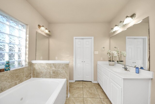 full bath with a bath, tile patterned flooring, vanity, and baseboards