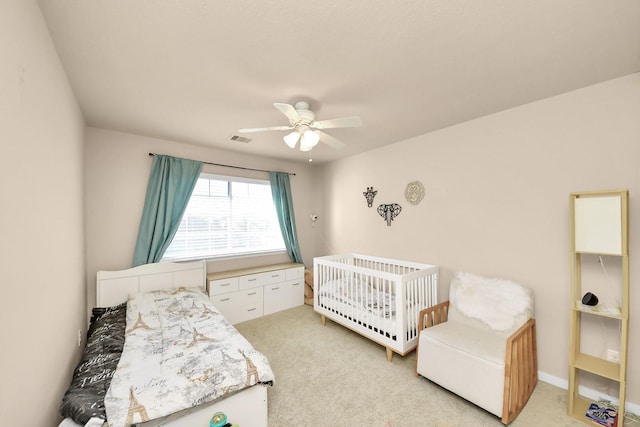 bedroom featuring visible vents, light colored carpet, and a ceiling fan