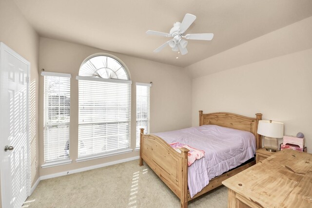 bedroom featuring a ceiling fan, vaulted ceiling, light colored carpet, and baseboards