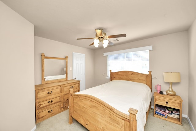 bedroom with visible vents, baseboards, light colored carpet, and ceiling fan