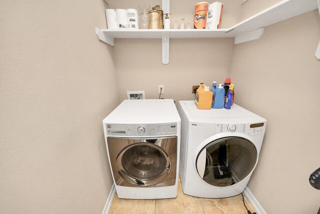 laundry room with laundry area, washer and dryer, and baseboards