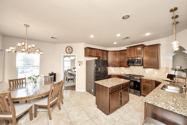 kitchen featuring light stone countertops, visible vents, appliances with stainless steel finishes, and a sink