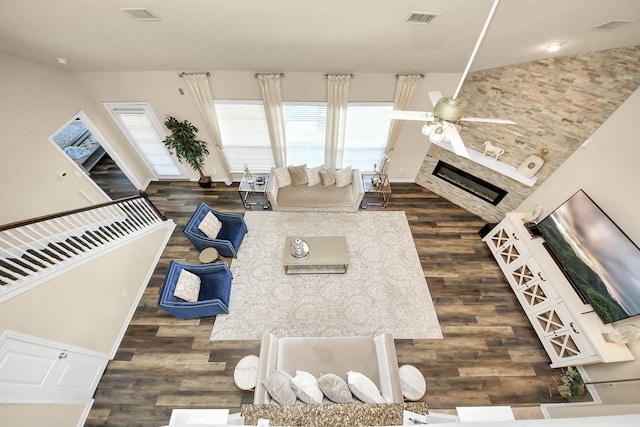 living room featuring ceiling fan, a fireplace, visible vents, and a healthy amount of sunlight