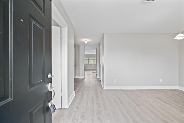 foyer featuring visible vents, baseboards, and light wood-style flooring