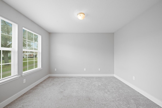 carpeted spare room featuring baseboards