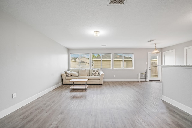 unfurnished room featuring visible vents, baseboards, and wood finished floors