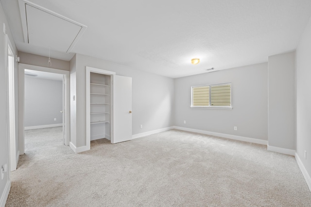 interior space with visible vents, a closet, carpet, baseboards, and attic access