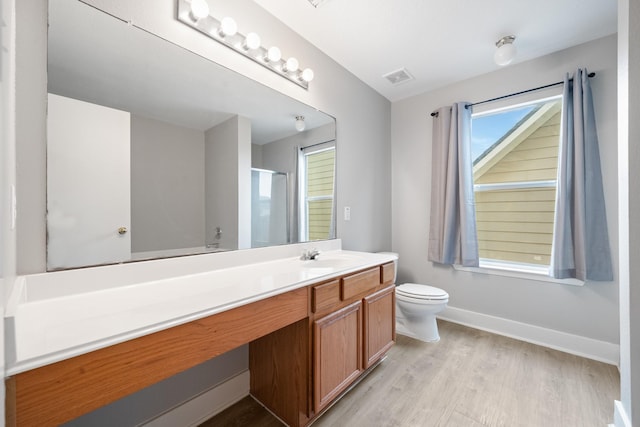 bathroom with visible vents, a shower stall, baseboards, wood finished floors, and vanity