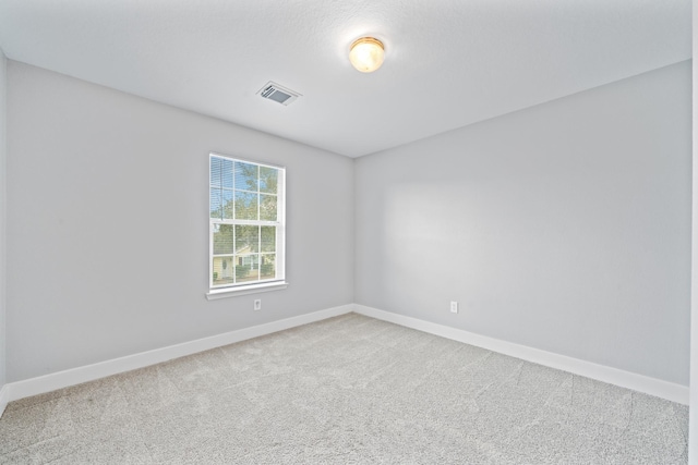 carpeted empty room featuring visible vents and baseboards