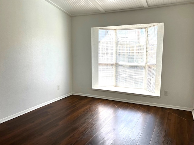 spare room featuring hardwood / wood-style flooring, plenty of natural light, and baseboards