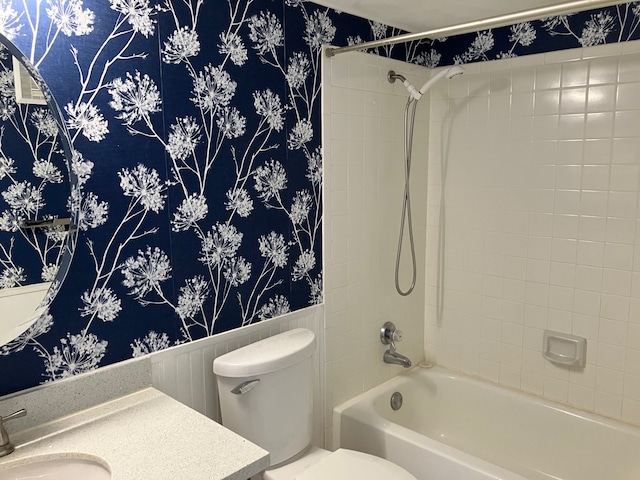 full bath featuring toilet, wainscoting, wallpapered walls, tub / shower combination, and vanity