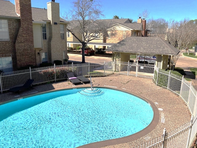 community pool with a gazebo, a patio, and fence