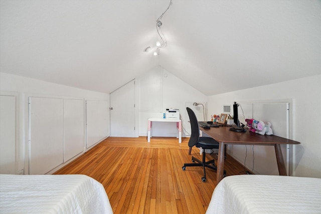 bedroom featuring light wood finished floors and vaulted ceiling