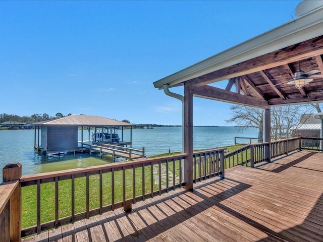 view of dock with a lawn, a water view, and boat lift