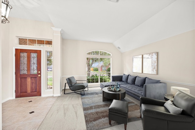 tiled living area featuring lofted ceiling, a notable chandelier, and baseboards