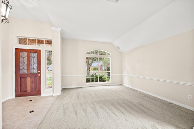 foyer with baseboards, a notable chandelier, and vaulted ceiling