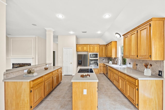 kitchen with backsplash, a fireplace, appliances with stainless steel finishes, and a kitchen island