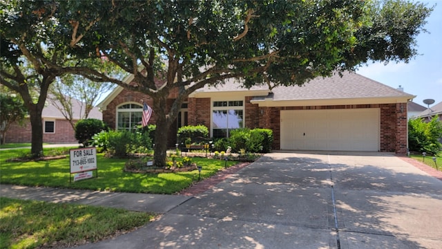 view of front facade featuring a front lawn, a garage, brick siding, and driveway