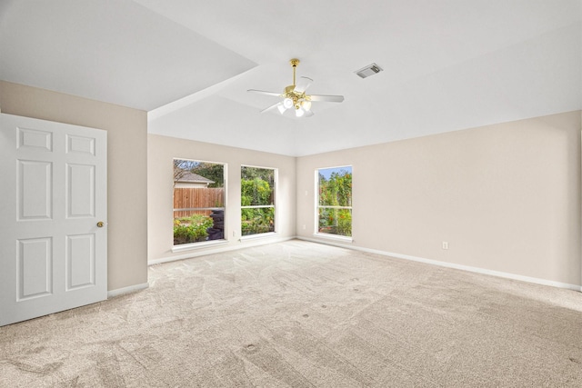 carpeted empty room with visible vents, baseboards, lofted ceiling, and a ceiling fan